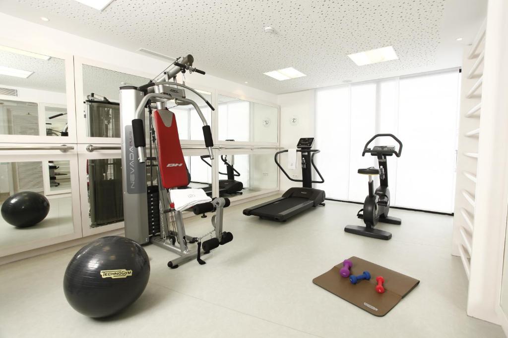 a gym with several tread machines and a treadmill at Dar El Marsa Hotel & Spa in La Marsa
