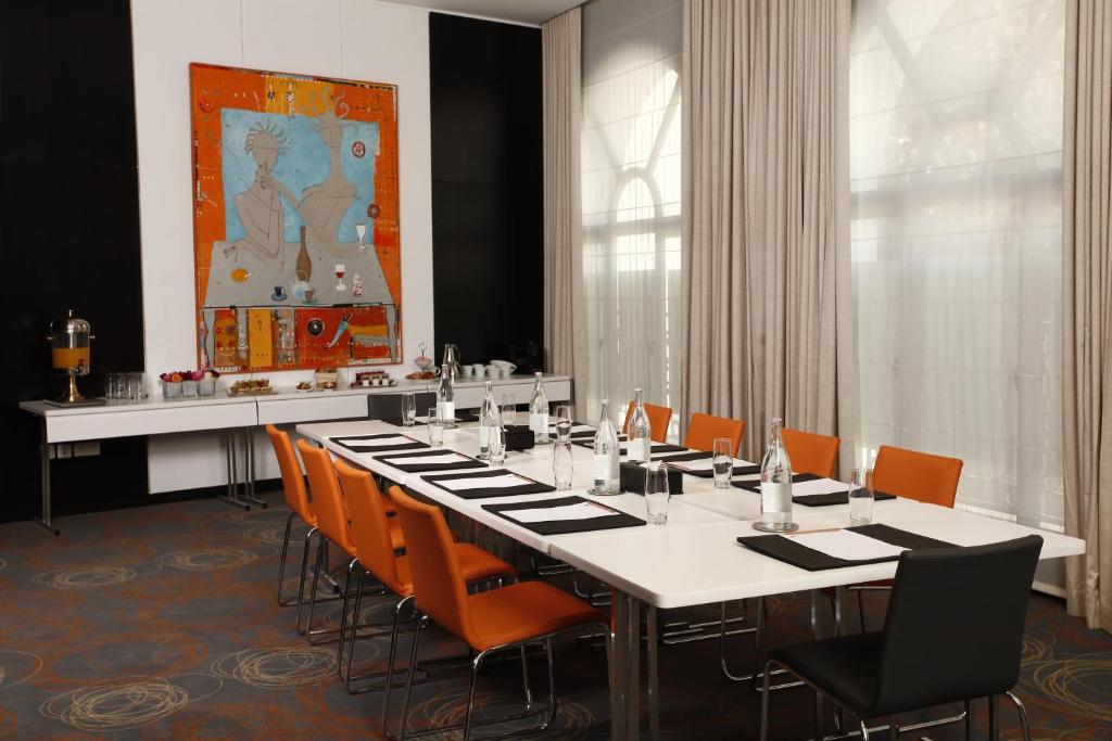 a dining room with a long table and orange chairs at Dar El Marsa Hotel & Spa in La Marsa