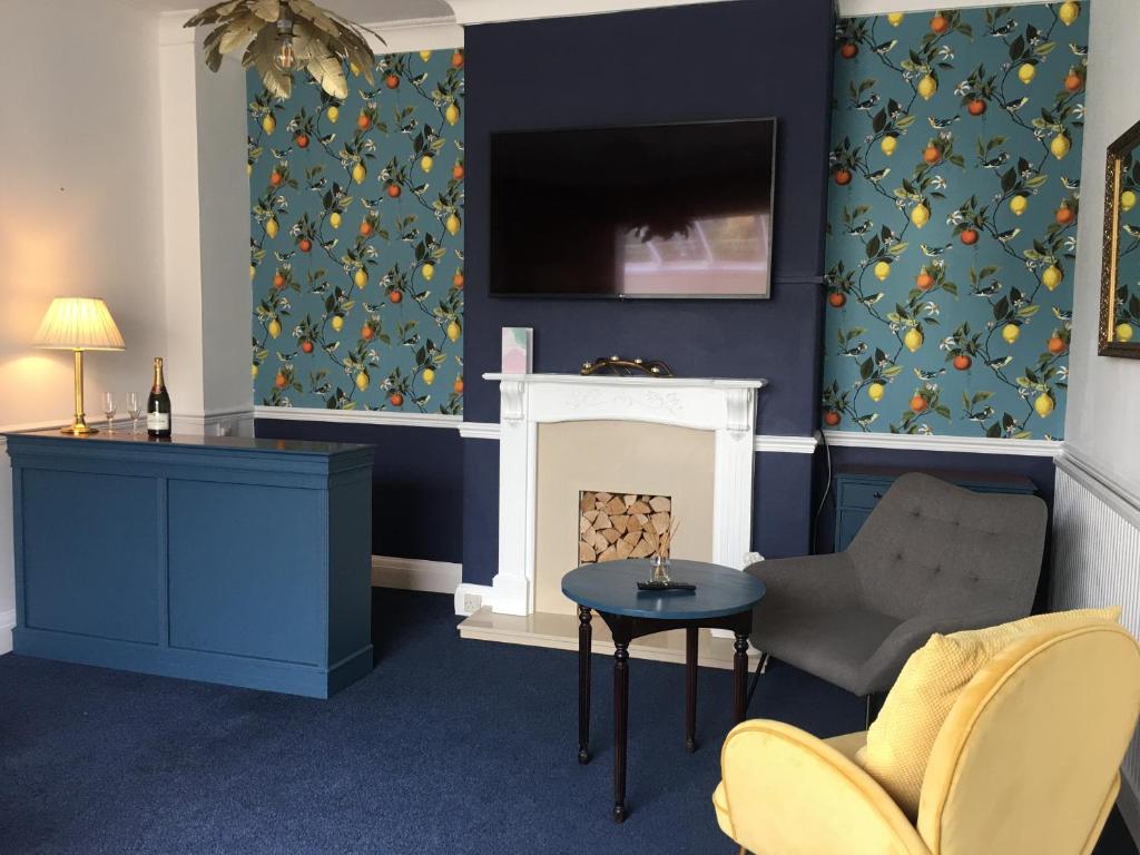 a living room with a fireplace and a tv at The Millbrook B&B in Torquay