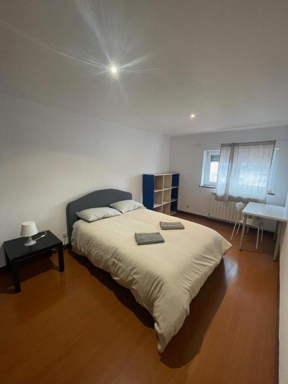 Un dormitorio con una cama grande y una mesa. en Picadeiro A, en Bragança