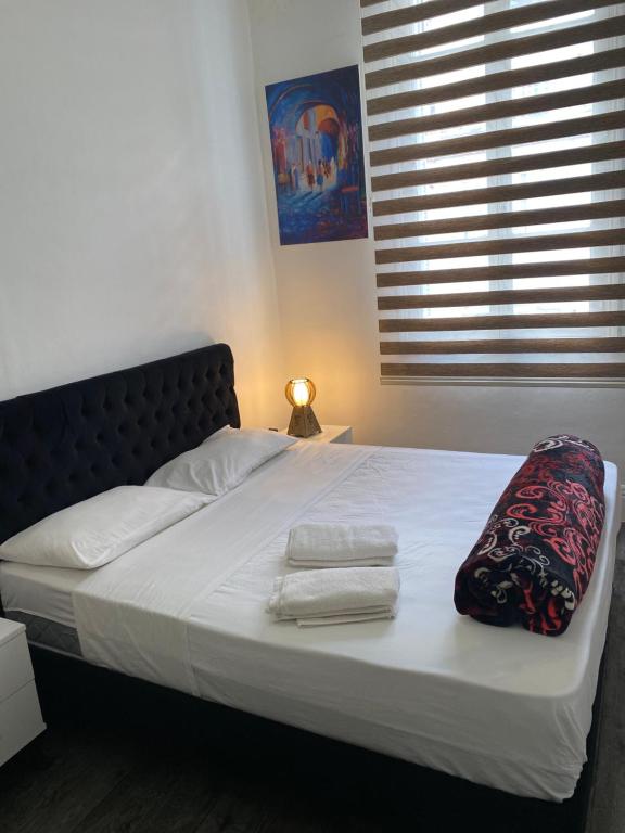 a bed with white sheets and towels on it at Appartement Tunis in Tunis