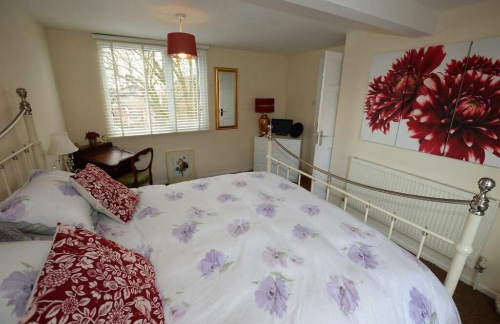 a bedroom with a large white bed with flowers on it at Lime Stays in Derby