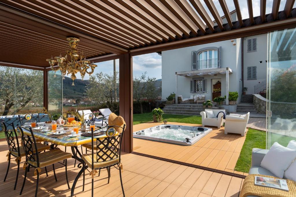 eine Terrasse mit einem Tisch, Stühlen und einem Pool in der Unterkunft Torrigiani Apartments in Quarrata
