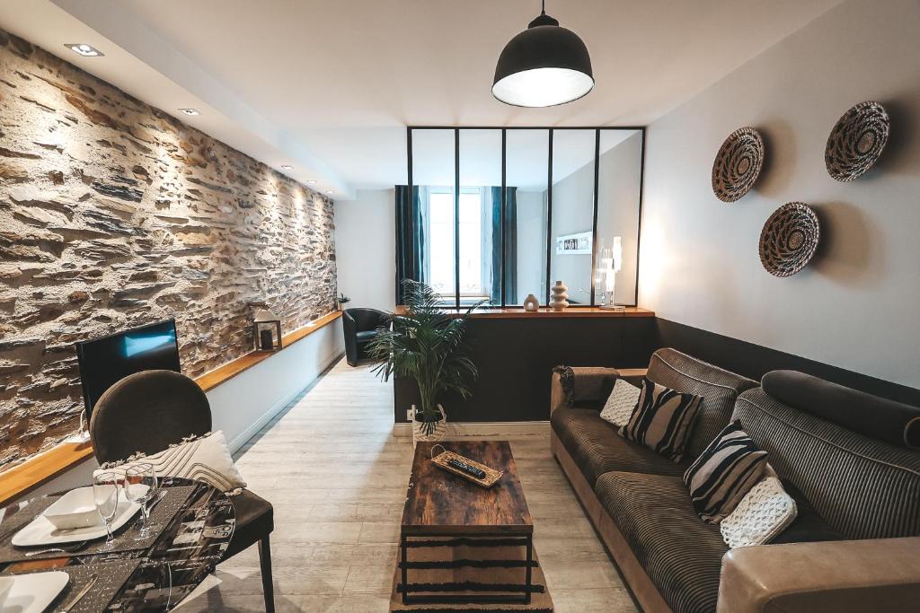 sala de estar con sofá y chimenea en Suit'Home Commerce en Angers