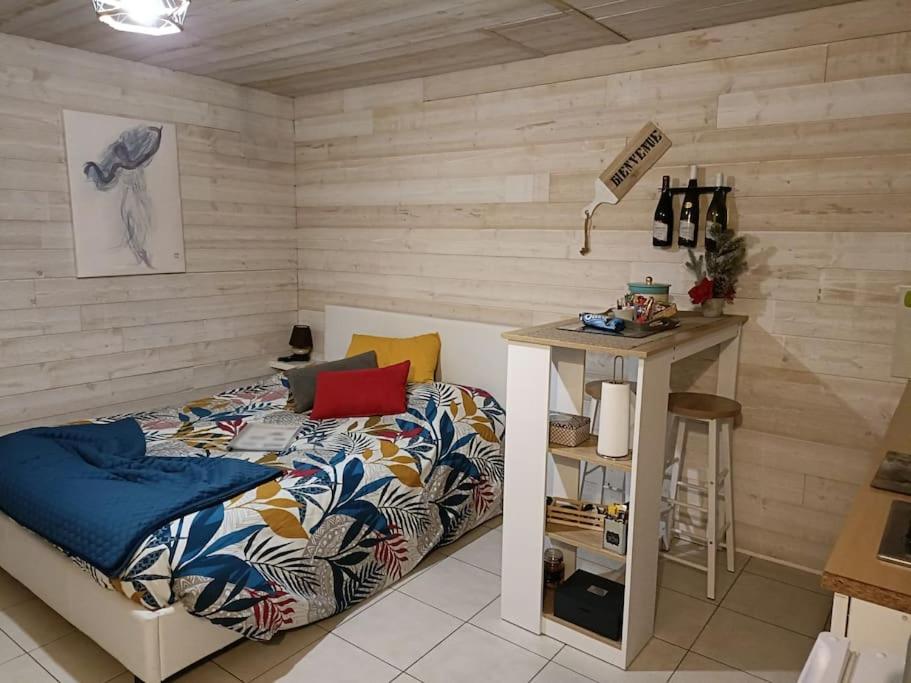 ein Schlafzimmer mit einem Bett und einem Tisch mit einer Lampe in der Unterkunft Maison indépendante parfaite pour tous voyageurs. in Le Landreau