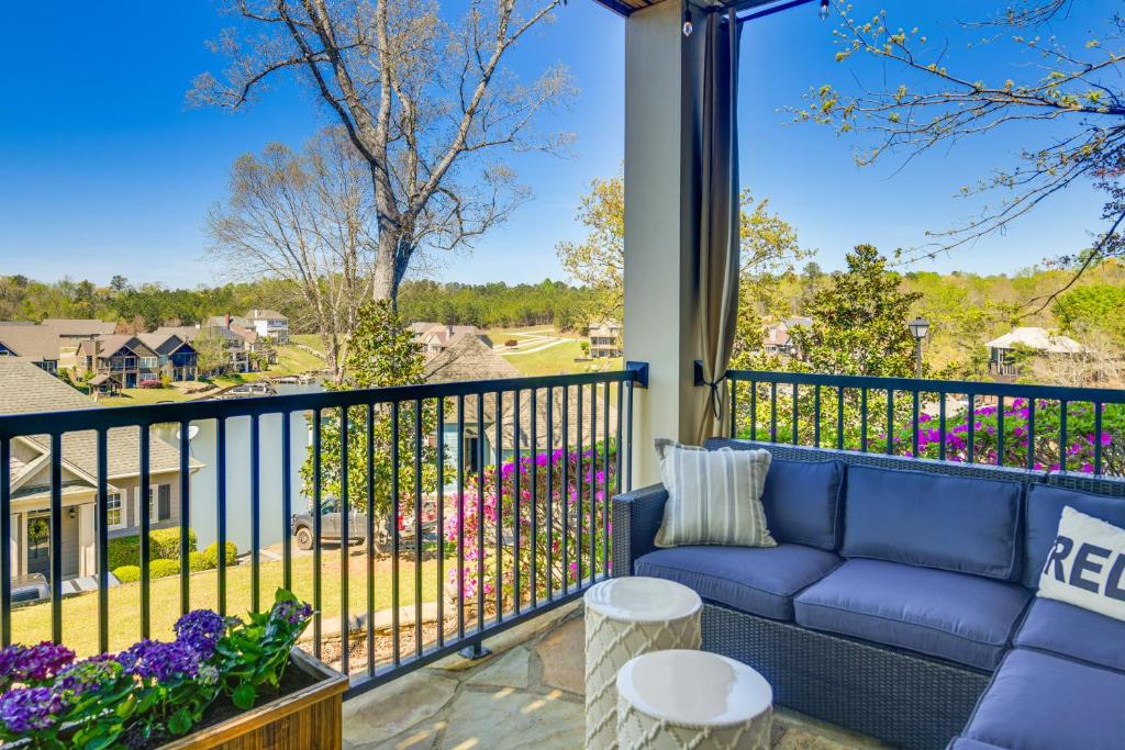 een blauwe bank op een balkon met uitzicht op een tuin bij Lake Martin Condo with Community Perks and Views! in Dadeville