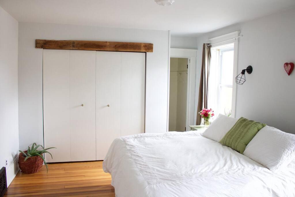 een slaapkamer met een wit bed en een grote kast bij Garden Guesthouse in Viroqua