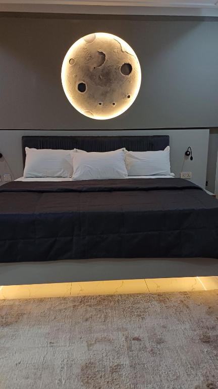 a bedroom with a bed with a moon light above it at Box 55-Moon Apartment in Enugu