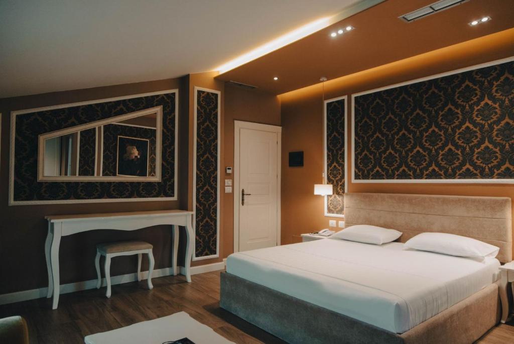 um quarto com uma cama grande e uma lareira em Atrium Hotel em Tirana