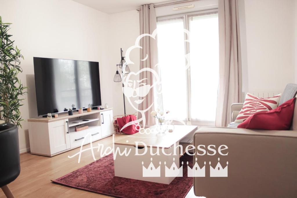 a living room with a couch and a flat screen tv at *Claire : Appartement avec *balcon + parking* in Mantes-la-Jolie