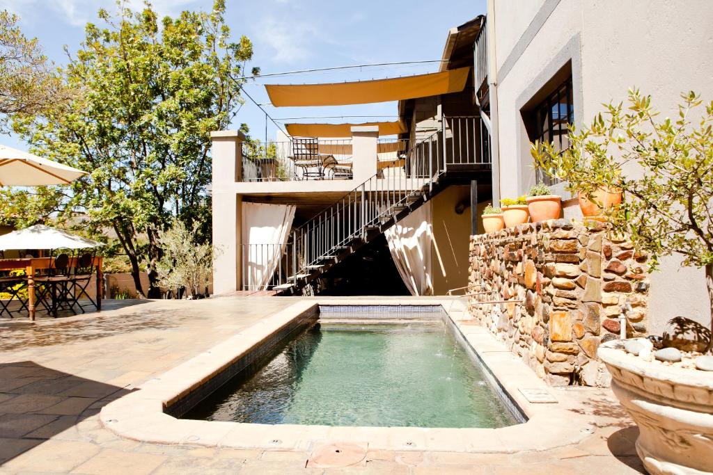 a swimming pool in the courtyard of a house at Olive Grove Guesthouse in Windhoek