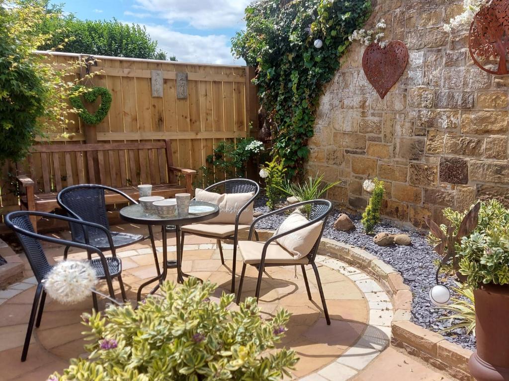 a patio with a table and chairs in a garden at 3 bed in Brompton 85761 in Brompton