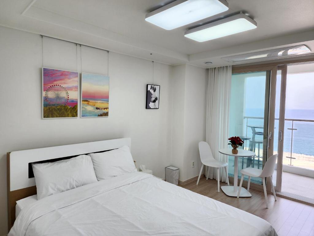 a bedroom with a bed and a table with chairs at Sokcho Summitbay 1209 "Ocean View" in Sokcho