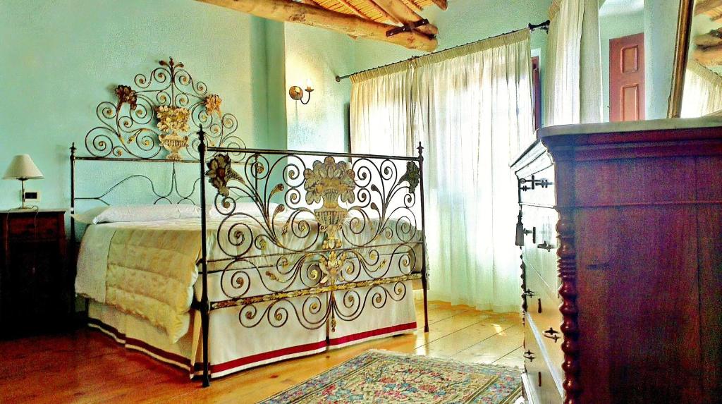 a bedroom with a bed and a dresser in it at Il Borgo dell'Arcangelo in Barùmini