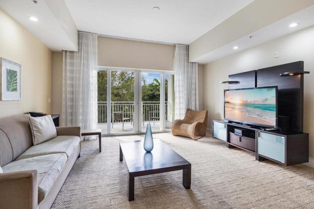 ein Wohnzimmer mit einem Sofa und einem Flachbild-TV in der Unterkunft Villa Vista-2 Story w 3Bdrms & Golf View in Miami