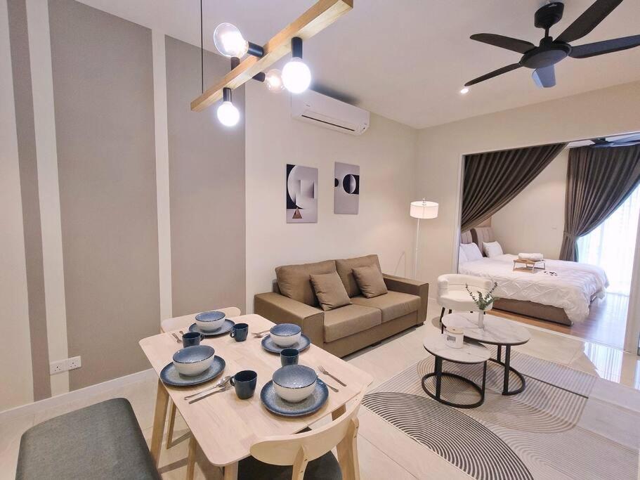 een woonkamer met een bank en een tafel met borden erop bij KLCC/PavilionKL/Monorail/3Pax FreeParking A in Kuala Lumpur