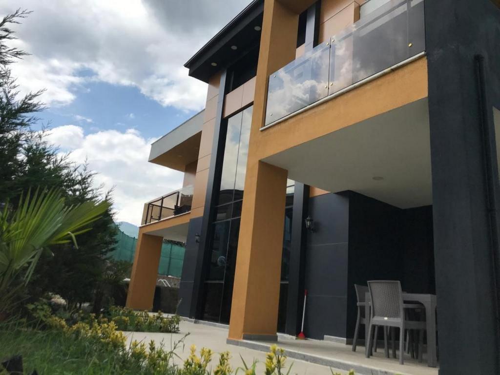 uma casa com portas de vidro e cadeiras no pátio em DSF Villas & SPA A16 em Kırkpınar