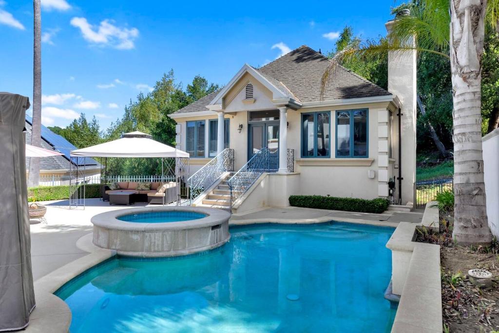 ein Haus mit einem Pool vor einem Haus in der Unterkunft Morgan Hill Elegance Spa & Pool Retreat in Morgan Hill