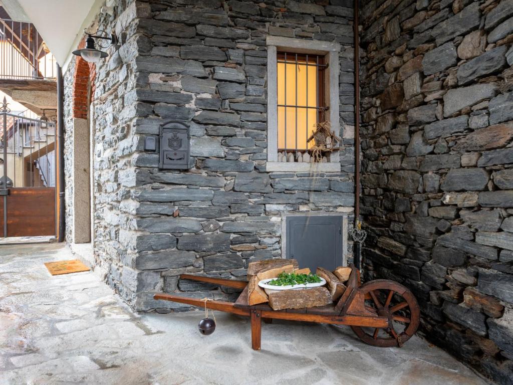 un muro di pietra con carrello di legno accanto a un edificio di Holiday Home Silvia by Interhome a Mergozzo