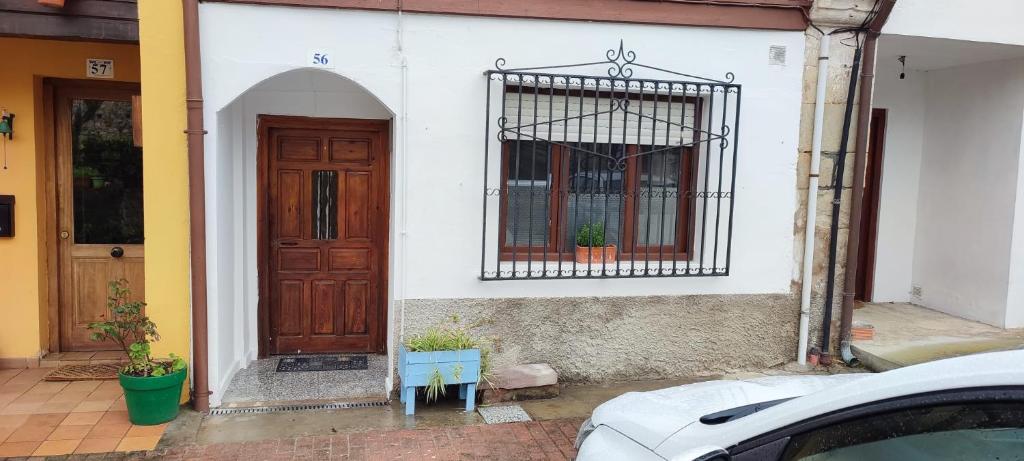 een wit gebouw met een deur en een raam bij Rincon de Valdaliga in Valdaliga 