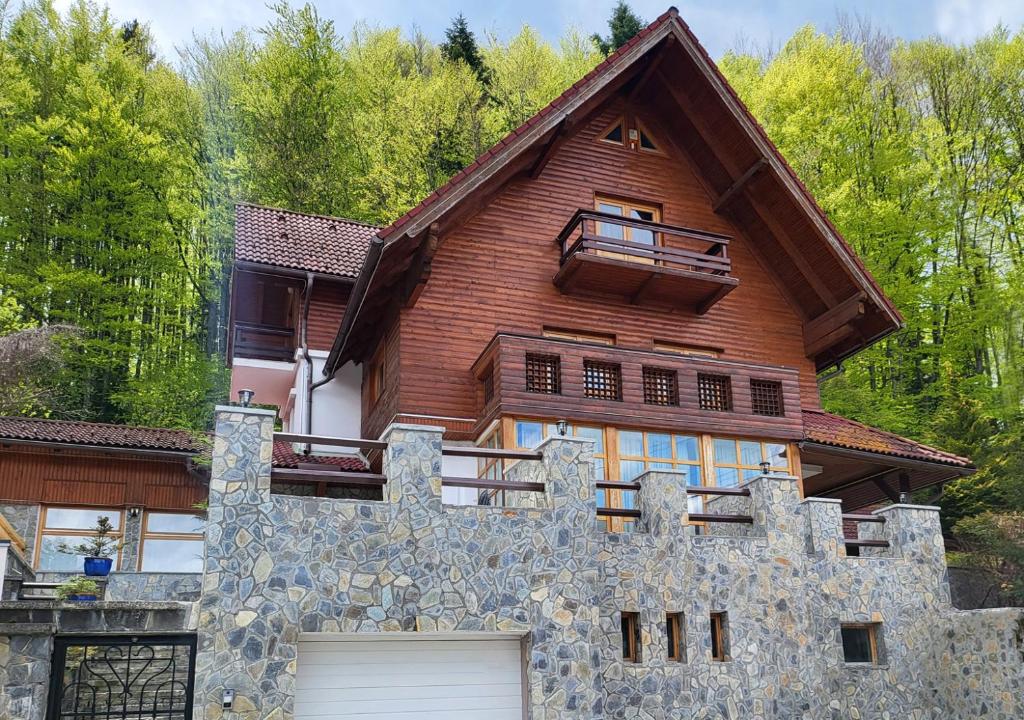 a large wooden house with a gate and a garage at ALISIO in Sinaia