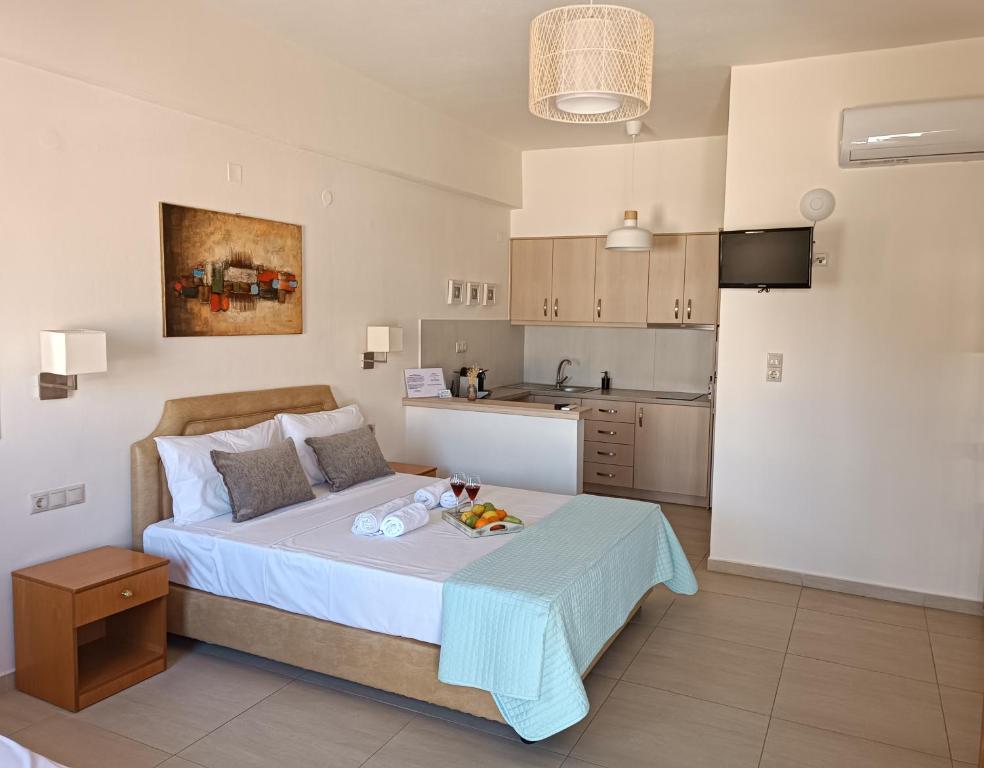 a small bedroom with a bed and a kitchen at Superior Savvas Apartments by the sea in Agia Pelagia
