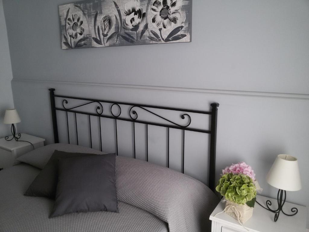 Un dormitorio con una cama negra con flores sobre una mesa en I Marinaretti, en Siracusa