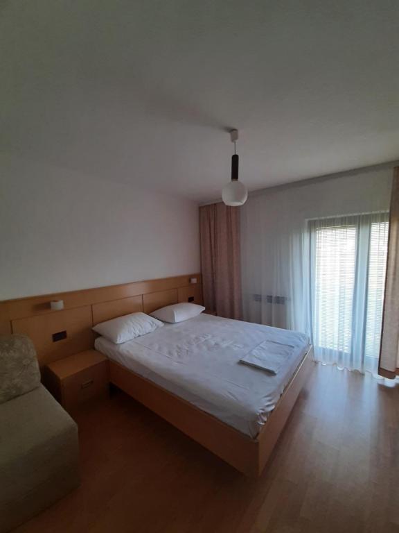 a bedroom with a large bed and a couch at Apartman Juresic in Rab