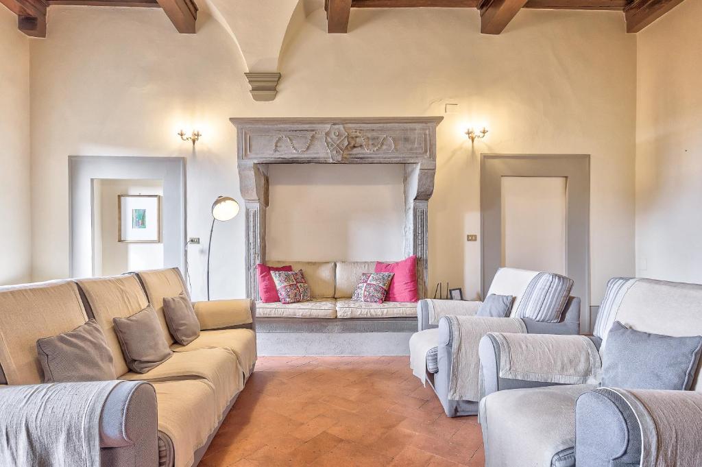 ein Wohnzimmer mit einem Sofa und Stühlen in der Unterkunft Casa Coppi - Together in Tuscany in Cortona