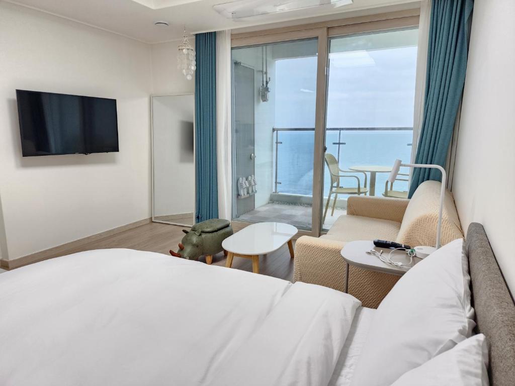 a hotel room with a bed and a view of the ocean at Sokcho Summitbay 1704 "Ocean View" in Sokcho