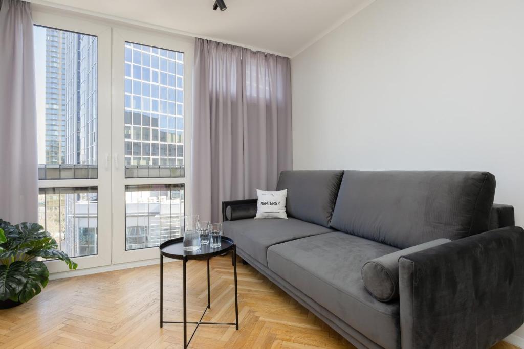 a living room with a couch and a table at Apartment with Parking in the Heart of Warsaw by Rent like home in Warsaw