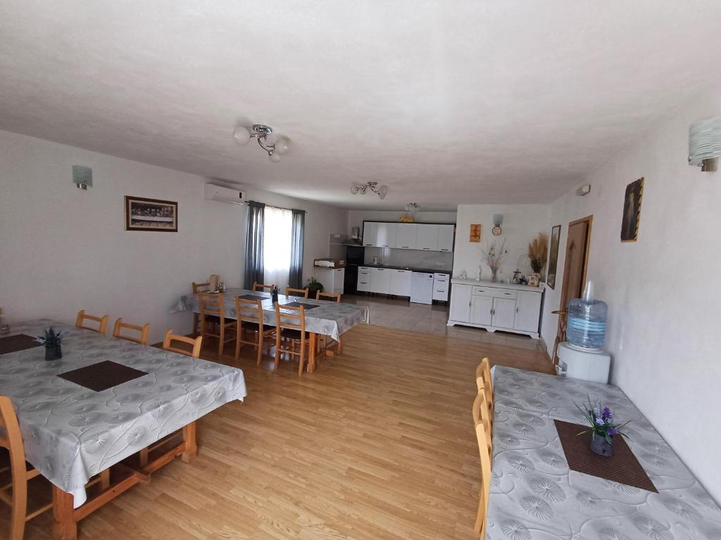 a living room with tables and chairs and a kitchen at Villa Ana in Međugorje