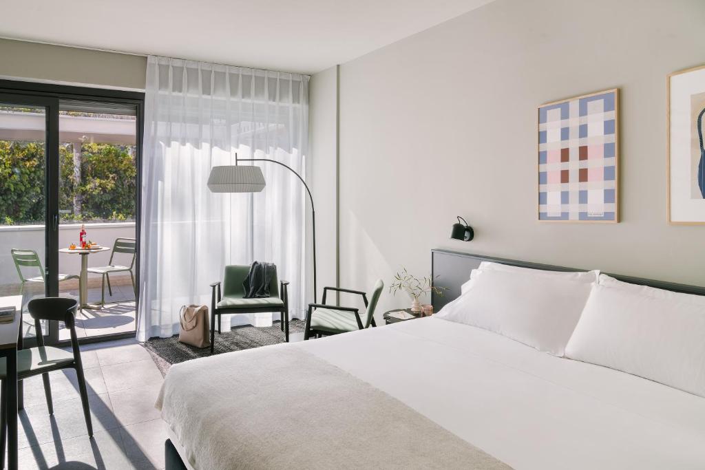 a bedroom with a bed and a balcony with a table at Sonder Testaccio in Rome