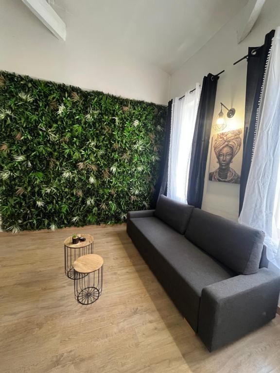 a living room with a couch and a green wall at Charmant Duplex centre de nimes in Nîmes