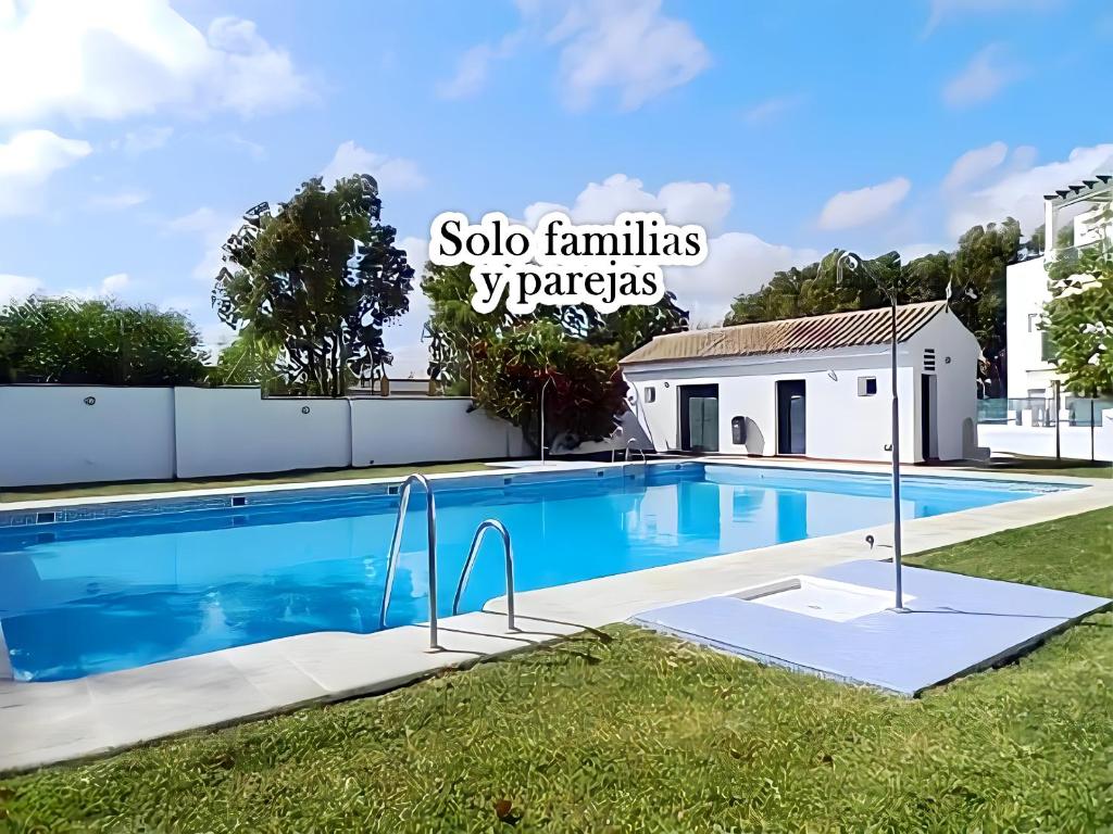 - une piscine dans une cour à côté d'un bâtiment dans l'établissement Apartamento junto al mar Piscina solo familias, à Conil de la Frontera