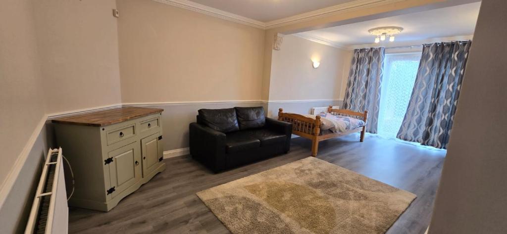 a living room with a chair and a dresser at Avala, 5/6 Bed House in Romford in Great Warley Street
