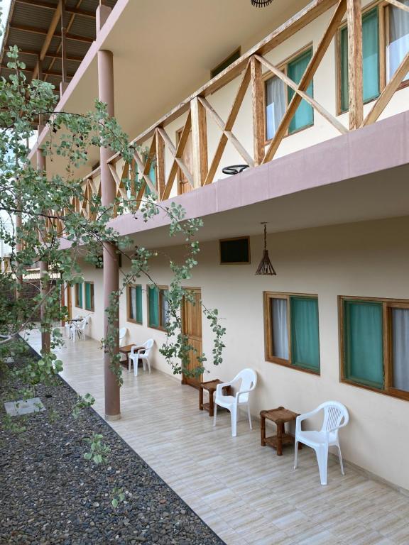 ein Gebäude mit Tischen und Stühlen im Innenhof in der Unterkunft Casamar in Máncora