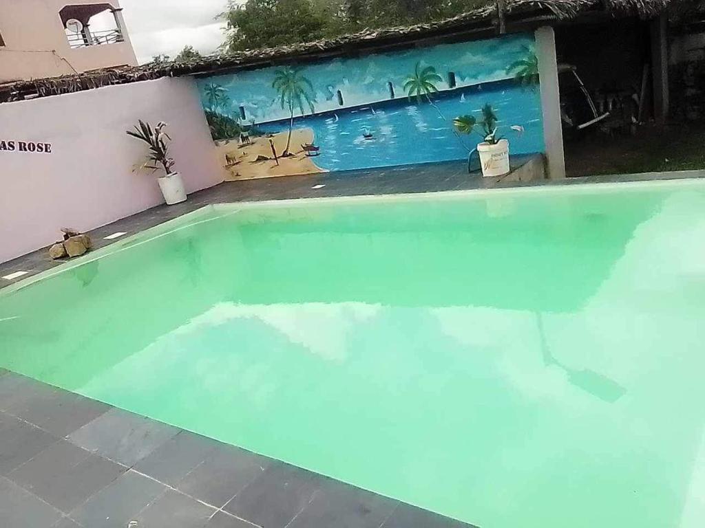 una piscina llena de agua con una pintura en la pared en Résidence Lilas Rose, en Andilana