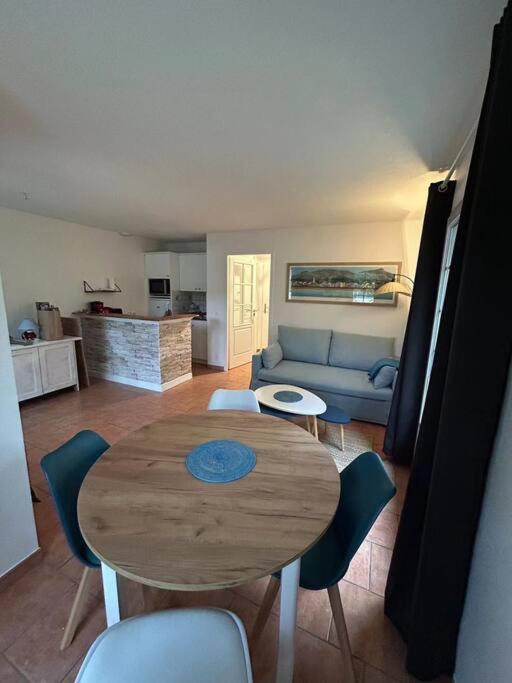 un salon avec une table et des chaises en bois dans l'établissement Charmante maison dans résidence avec piscine proche golf et plage, à Moliets-et-Maa