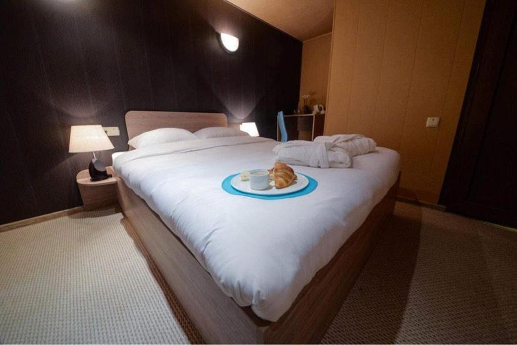 un gato acostado en una cama con un plato. en VIP apart 798, en Tiflis