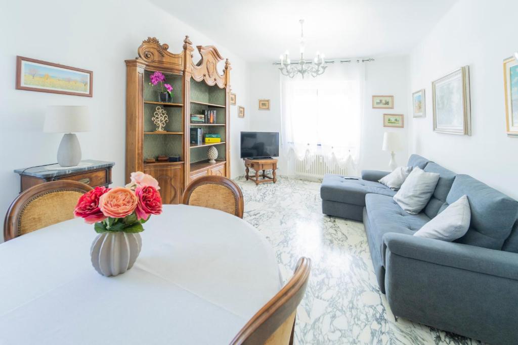 ein Wohnzimmer mit einem Tisch und einem blauen Sofa in der Unterkunft 147- Ca' da Lice nel centro di Sestri Levante, 5 minuti Baia del Silenzio, Mare e Spiaggia in Sestri Levante