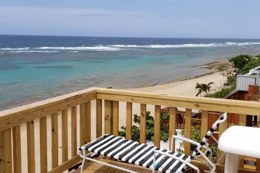 un balcone in legno con panchina e spiaggia di Shacks beachfront 2bdrm w/deck a Isabela