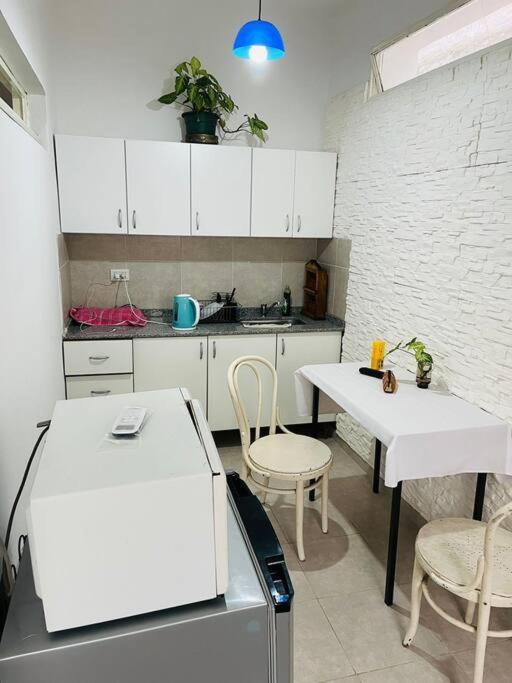 una cucina con mobili bianchi e tavoli e sedie bianchi di Dpto. céntrico San Lucas a Río Cuarto