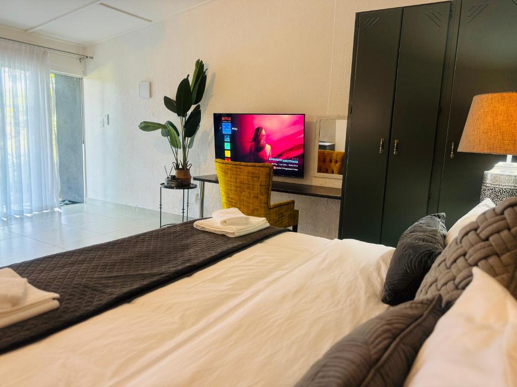 a bedroom with a large bed with a tv on it at Busa House in White River