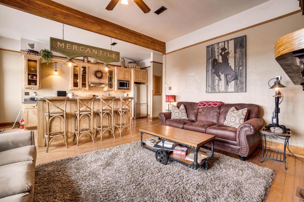 uma sala de estar com um sofá e uma mesa em Historic DT Laramie Apartment Deck and 1 Mi to UW! em Laramie