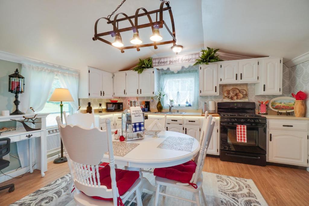 uma cozinha com armários brancos, uma mesa e um lustre em Sweet Lily Home Less Than 15 Mi from Downtown Corbin! 