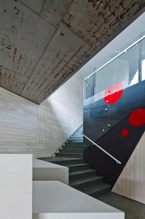 a staircase in a building with a red object on the wall at Pensiunea Atra Doftana in Teşila
