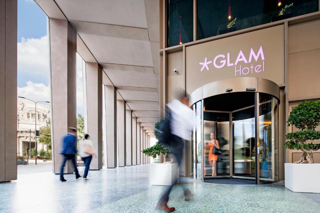 a group of people walking in front of a building at Glam Milano in Milan