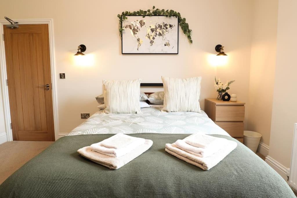 a bedroom with a bed with towels on it at Green Nest Room with private bathroom in Eastbourne