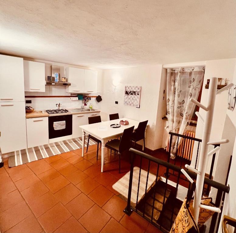 - une cuisine avec une table et des chaises dans la chambre dans l'établissement Casa al Campanile Tameró HolyDay Apartments, à Bocchignano